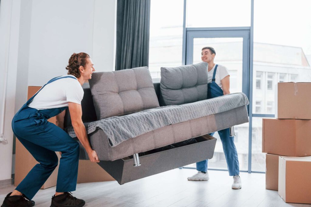 zwei menschen tragen ein sofa